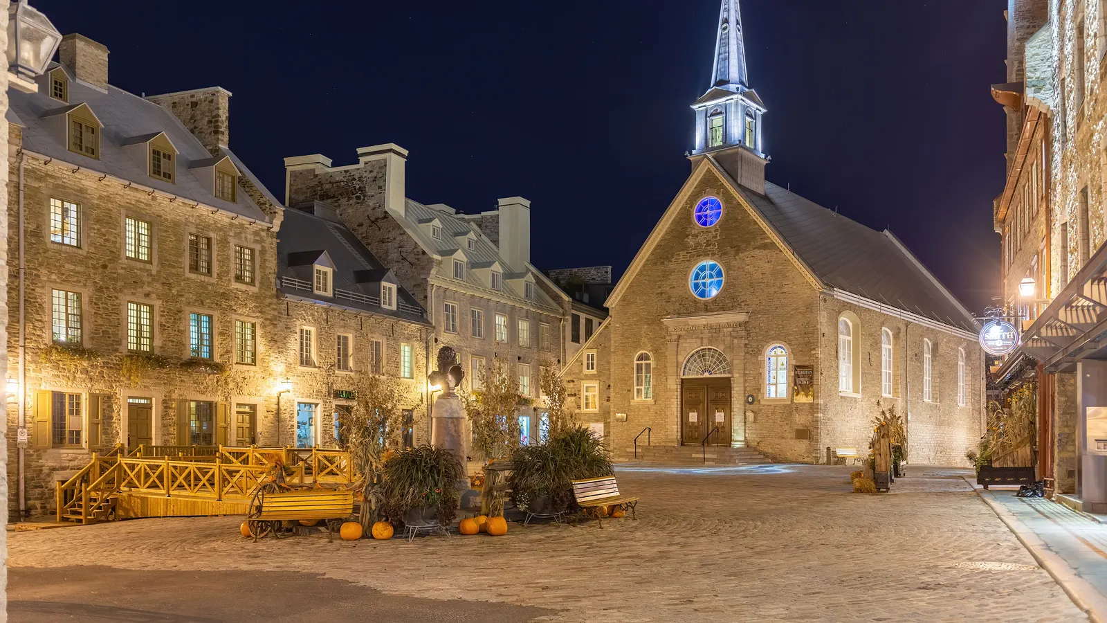 Place Royale à Québec de nuit, avec l'église Notre-Dame-des-Victoires éclairée et des maisons de pierre